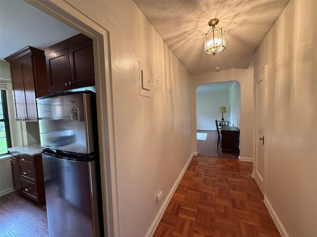 198 Garth Rd Unit 1D, Scarsdale, NY 10583 - hall featuring baseboards, arched walkways, and a textured ceiling