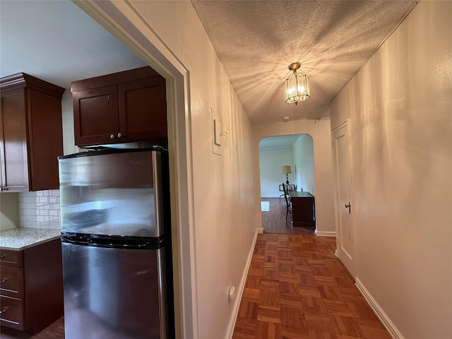198 Garth Rd Unit 1D, Scarsdale, NY 10583 - hall featuring arched walkways, baseboards, and a textured ceiling