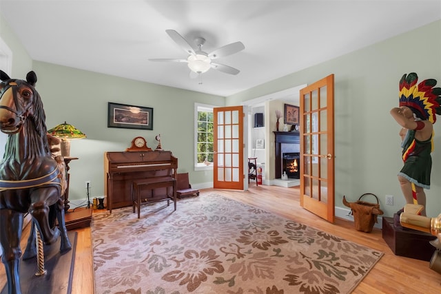 138 Jansen, Holmes, NY 12531 - sitting room with french doors, a lit fireplace, ceiling fan, and wood finished floors