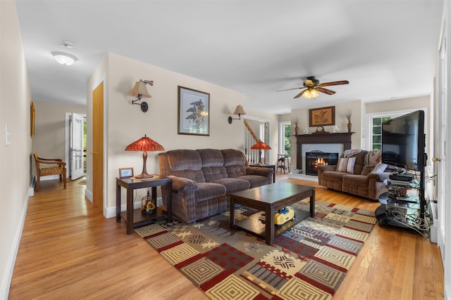 138 Jansen, Holmes, NY 12531 - living room with light wood-style floors, a lit fireplace, and ceiling fan