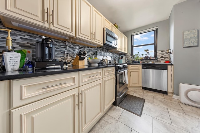 1 Jefferson Ave Unit B12, Rockville Centre, NY 11570 - kitchen featuring stainless steel appliances, tasteful backsplash, cream cabinets, and dark countertops