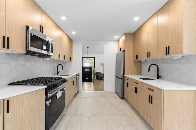 311 Hungry Harbor Rd, North Woodmere, NY 11581 - kitchen featuring appliances with stainless steel finishes, a sink, light countertops, light brown cabinets, and recessed lighting
