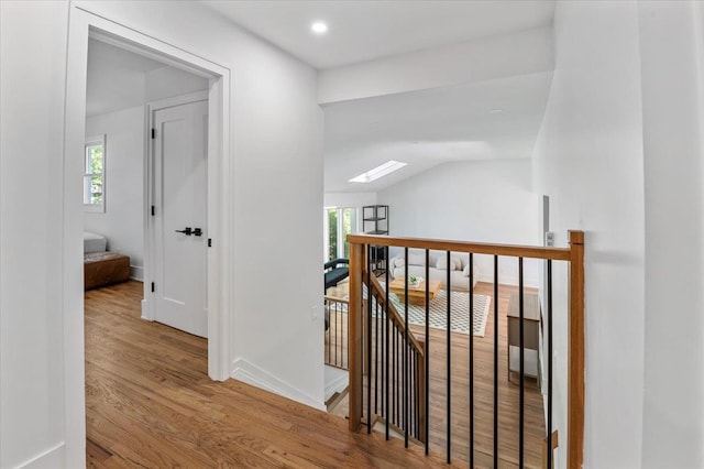 311 Hungry Harbor Rd, North Woodmere, NY 11581 - corridor featuring an upstairs landing, wood finished floors, a skylight, lofted ceiling, and baseboards