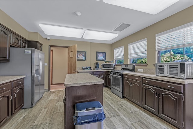 291 Starling Ct, Manhasset, NY 11030 - kitchen featuring stainless steel appliances, light countertops, light wood finished floors, and a center island