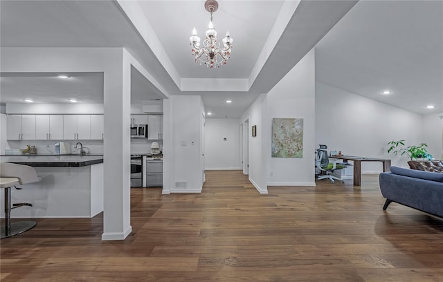 291 Starling Ct, Manhasset, NY 11030 - entryway with a chandelier, baseboards, recessed lighting, dark wood-type flooring, and a raised ceiling