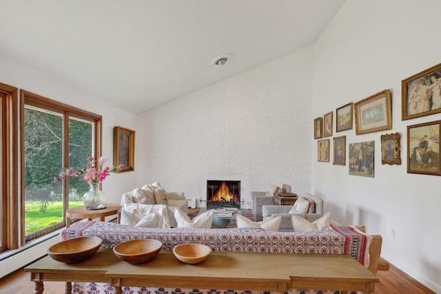 35 Old Farms Rd, Poughkeepsie, NY 12603 - living area with wood finished floors, healthy amount of natural light, a lit fireplace, a baseboard heating unit, and vaulted ceiling