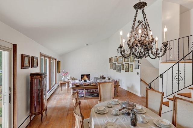 35 Old Farms Rd, Poughkeepsie, NY 12603 - dining area featuring vaulted ceiling, wood finished floors, a baseboard radiator, a chandelier, and stairs
