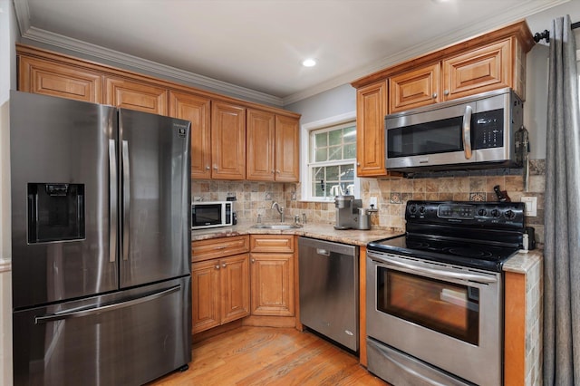 129 Michel Ave, Farmingdale, NY 11735 - kitchen featuring appliances with stainless steel finishes, light wood-style floors, light stone counters, crown molding, and tasteful backsplash