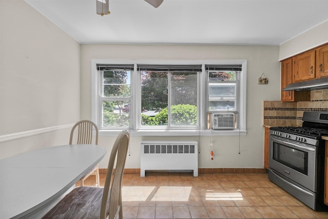 4 Leewood Cir Unit 4L, Eastchester, NY 10709 - kitchen with radiator, gas range, under cabinet range hood, decorative backsplash, and brown cabinets