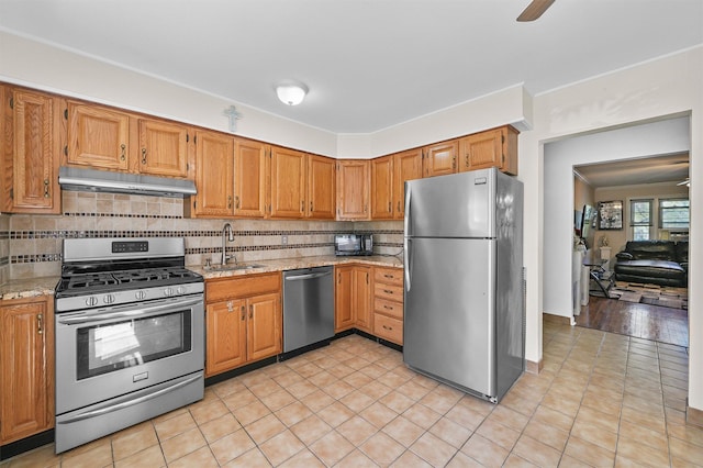 4 Leewood Cir Unit 4L, Eastchester, NY 10709 - kitchen featuring stainless steel appliances, under cabinet range hood, a sink, decorative backsplash, and light stone countertops