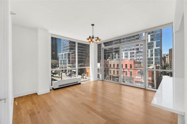 26-26 Jackson Ave Unit 402, Long Island City, NY 11101 - empty room featuring floor to ceiling windows, wood finished floors, a chandelier, and a view of city