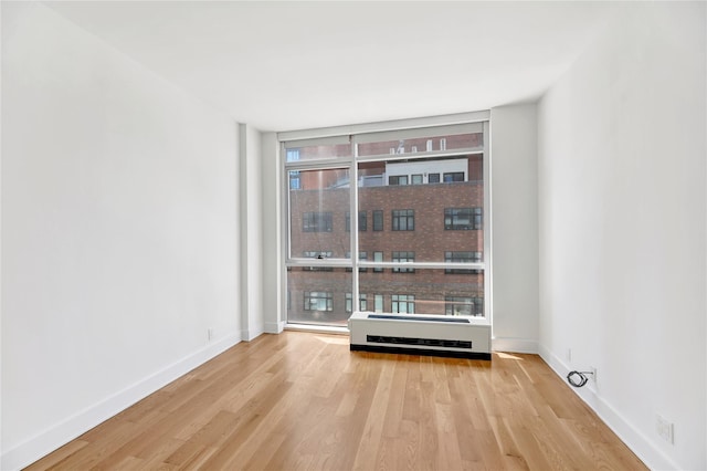 26-26 Jackson Ave Unit 402, Long Island City, NY 11101 - spare room featuring wood finished floors, floor to ceiling windows, and baseboards