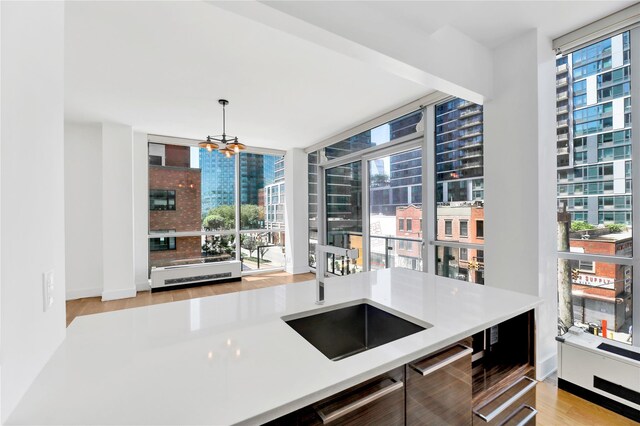 26-26 Jackson Ave Unit 402, Long Island City, NY 11101 - kitchen with light wood-type flooring, a chandelier, a city view, light countertops, and expansive windows