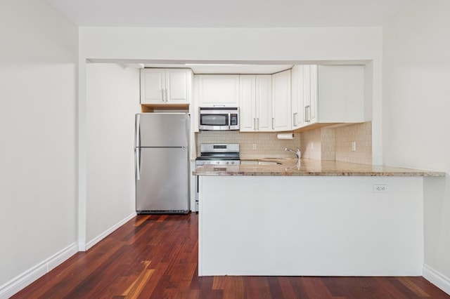 71-19 162nd St Unit 4E, Fresh Meadows, NY 11365 - kitchen with stainless steel appliances, light stone counters, decorative backsplash, dark wood-type flooring, and a peninsula