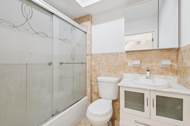 71-19 162nd St Unit 4E, Fresh Meadows, NY 11365 - bathroom featuring toilet, vanity, bath / shower combo with glass door, and tile walls