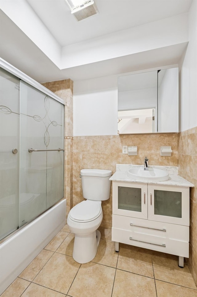 71-19 162nd St Unit 4E, Fresh Meadows, NY 11365 - full bath featuring toilet, vanity, combined bath / shower with glass door, tile patterned flooring, and tile walls