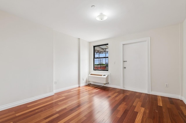 71-19 162nd St Unit 4E, Fresh Meadows, NY 11365 - unfurnished room with wood finished floors, a wall unit AC, and baseboards