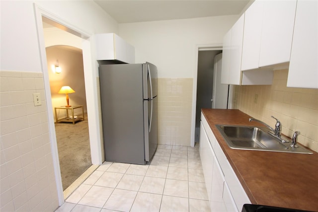 61-16 84th St, Middle Village, NY 11379 - kitchen with freestanding refrigerator, tile walls, a sink, white cabinets, and light tile patterned floors