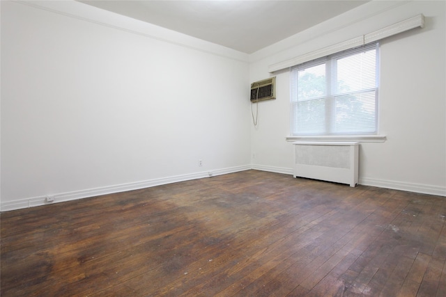 61-16 84th St, Middle Village, NY 11379 - spare room with radiator, dark wood-type flooring, a wall mounted AC, and baseboards