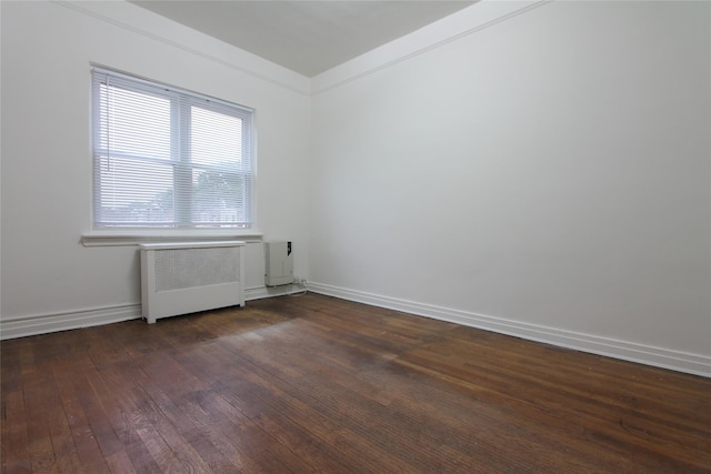 61-16 84th St, Middle Village, NY 11379 - unfurnished room with radiator, dark wood-style floors, and baseboards