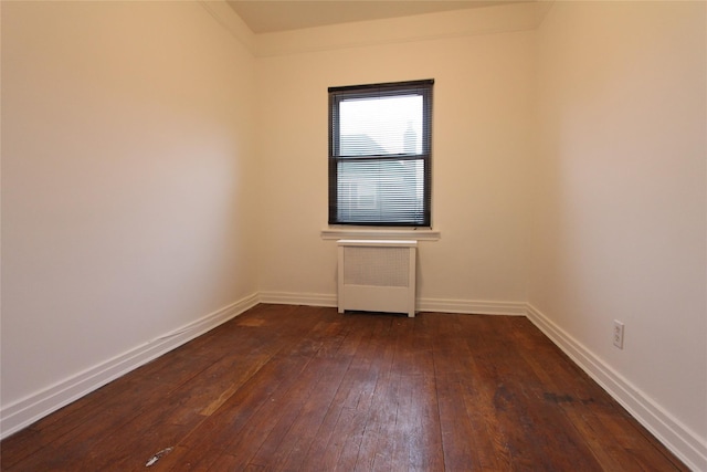 61-16 84th St, Middle Village, NY 11379 - spare room featuring radiator, dark wood-style floors, and baseboards