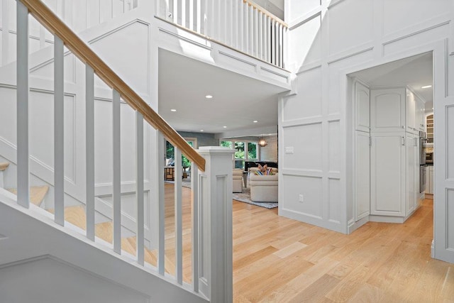 2 Field Ln, Roslyn Heights, NY 11577 - foyer with a decorative wall, stairway, light wood finished floors, and a towering ceiling