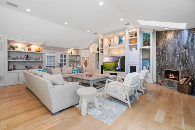 2 Field Ln, Roslyn Heights, NY 11577 - living room with vaulted ceiling, a fireplace, light wood-style flooring, built in shelves, and recessed lighting