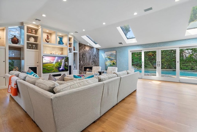 2 Field Ln, Roslyn Heights, NY 11577 - living area featuring a skylight, a high end fireplace, recessed lighting, light wood-style floors, and french doors