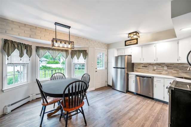 301 Maple Ave, Patchogue, NY 11772 - kitchen featuring appliances with stainless steel finishes, a baseboard radiator, plenty of natural light, and light countertops
