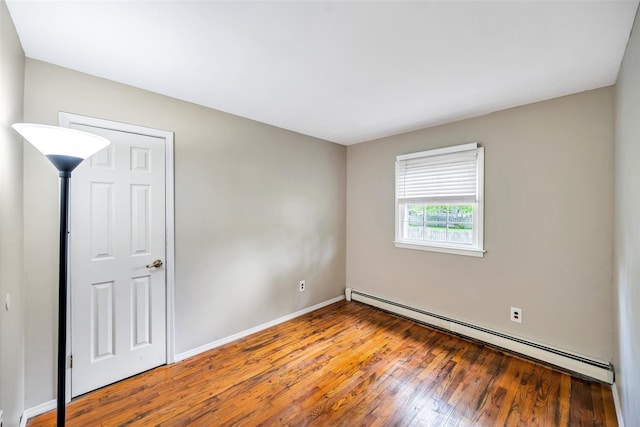 301 Maple Ave, Patchogue, NY 11772 - empty room with a baseboard radiator, hardwood / wood-style floors, and baseboards