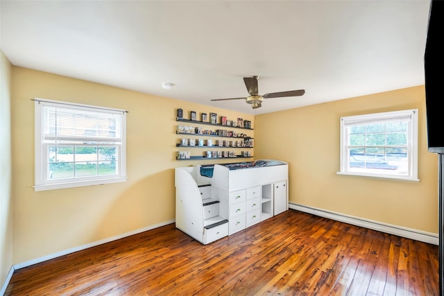 301 Maple Ave, Patchogue, NY 11772 - unfurnished bedroom with multiple windows, wood-type flooring, a baseboard heating unit, and baseboards