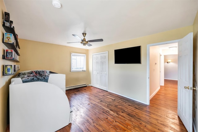 301 Maple Ave, Patchogue, NY 11772 - bedroom with a baseboard radiator, wood finished floors, a closet, baseboards, and ceiling fan