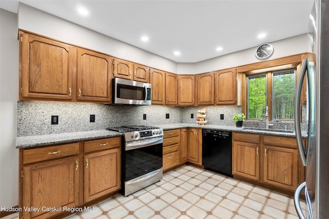 48 Deer Park Rd, Cairo, NY 12473 - kitchen with stainless steel appliances, a sink, light flooring, brown cabinets, and light stone countertops