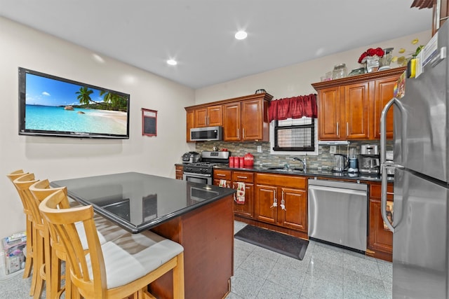 3632 Willett Ave, Bronx, NY 10467 - kitchen with appliances with stainless steel finishes, a sink, backsplash, a kitchen breakfast bar, and recessed lighting