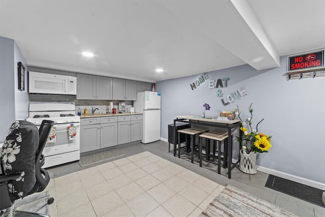3632 Willett Ave, Bronx, NY 10467 - kitchen with white appliances, a sink, light countertops, decorative backsplash, and gray cabinetry