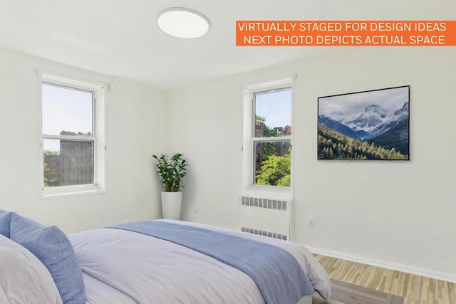 88-09 35th Ave Unit 5K, Jackson Heights, NY 11372 - bedroom featuring radiator heating unit, wood finished floors, and baseboards