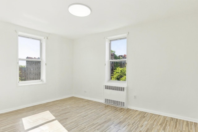 88-09 35th Ave Unit 5K, Jackson Heights, NY 11372 - spare room with radiator heating unit, wood finished floors, and baseboards
