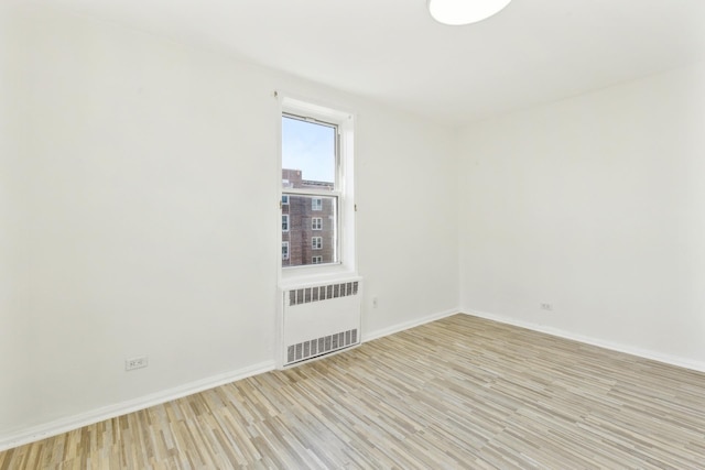 88-09 35th Ave Unit 5K, Jackson Heights, NY 11372 - unfurnished room with radiator, light wood-style floors, and baseboards