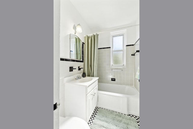88-09 35th Ave Unit 5K, Jackson Heights, NY 11372 - bathroom with tile walls, vanity, shower / tub combo, toilet, and a wainscoted wall