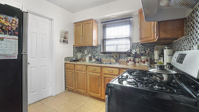 3217 Tenbroeck Ave, Bronx, NY 10469 - kitchen with stainless steel gas stove, freestanding refrigerator, light tile patterned floors, and tasteful backsplash