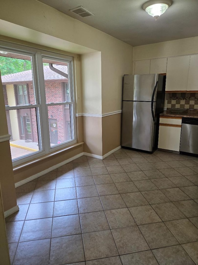 8 Cedar Ct Unit 8, Selden, NY 11784 - kitchen with stainless steel appliances, backsplash, white cabinetry, dark countertops, and baseboards