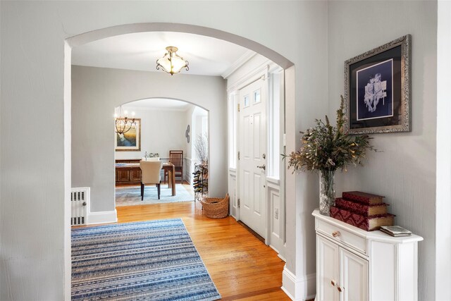 21 Deepdale Dr, Manhasset, NY 11030 - foyer entrance with light wood-style floors, radiator, arched walkways, and a chandelier