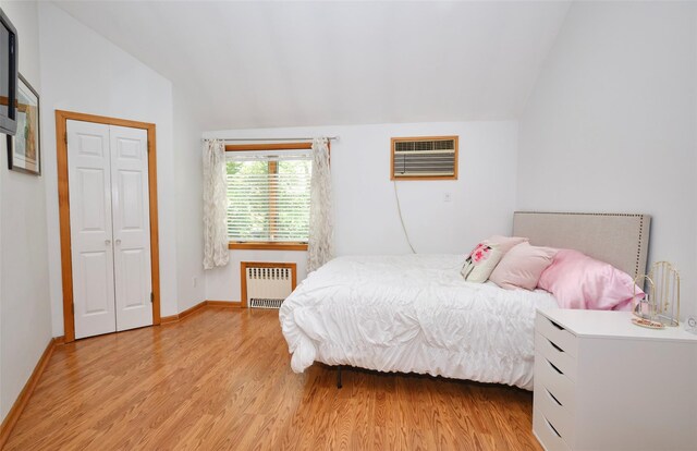 21 Deepdale Dr, Manhasset, NY 11030 - bedroom with radiator, lofted ceiling, an AC wall unit, light wood finished floors, and baseboards