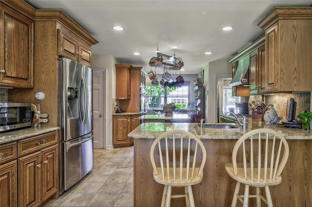 28 Valley Rd, Manhasset, NY 11030 - kitchen with stainless steel appliances, a peninsula, backsplash, light stone counters, and recessed lighting