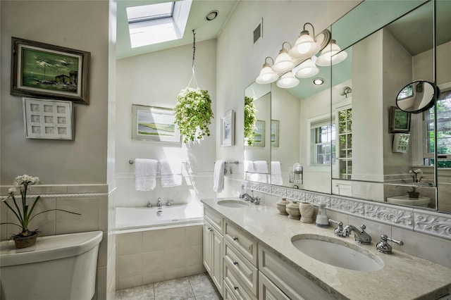 28 Valley Rd, Manhasset, NY 11030 - full bath with a skylight, toilet, double vanity, tiled bath, and tile patterned floors