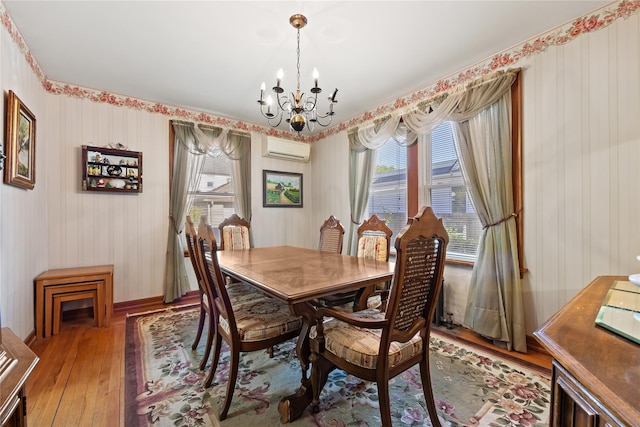 45-31 169th St, Flushing, NY 11358 - dining room with a chandelier, light wood-type flooring, a wall mounted AC, wallpapered walls, and baseboards