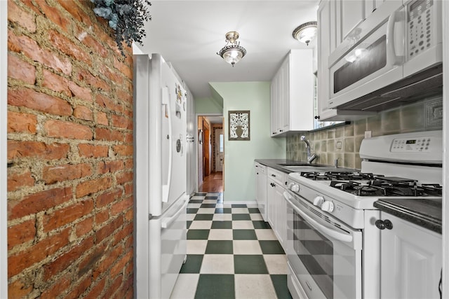 45-31 169th St, Flushing, NY 11358 - kitchen with white appliances, tile patterned floors, a sink, dark countertops, and brick wall