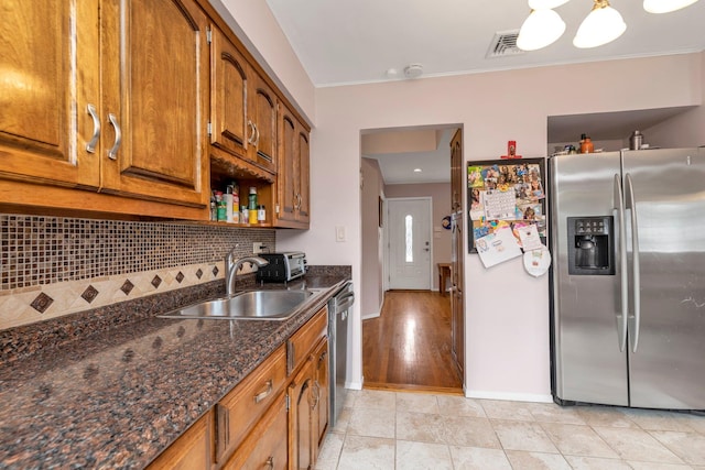 19 Alan Ct, Plainview, NY 11803 - kitchen featuring stainless steel appliances, a sink, tasteful backsplash, brown cabinetry, and baseboards
