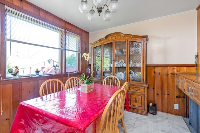 597 Stratford Rd, Baldwin, NY 11510 - dining area featuring wood walls, a chandelier, ornamental molding, light marble finish flooring, and a wainscoted wall