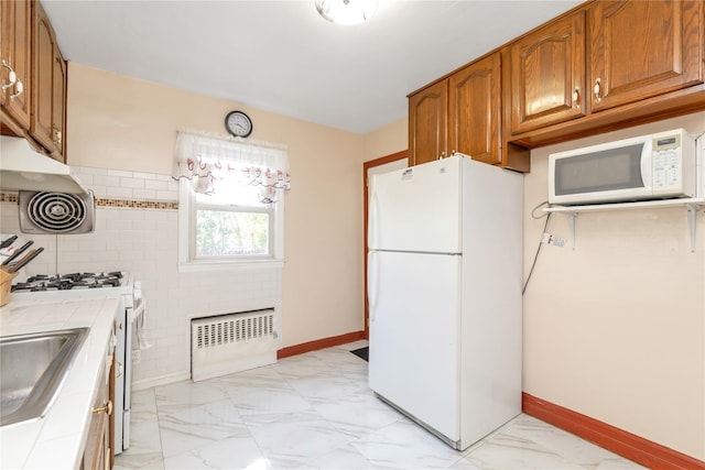 597 Stratford Rd, Baldwin, NY 11510 - kitchen featuring white appliances, tile counters, light marble finish floors, brown cabinetry, and radiator heating unit